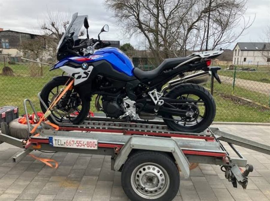 Motocykl BMW GS zamocowany pasami na przyczepie